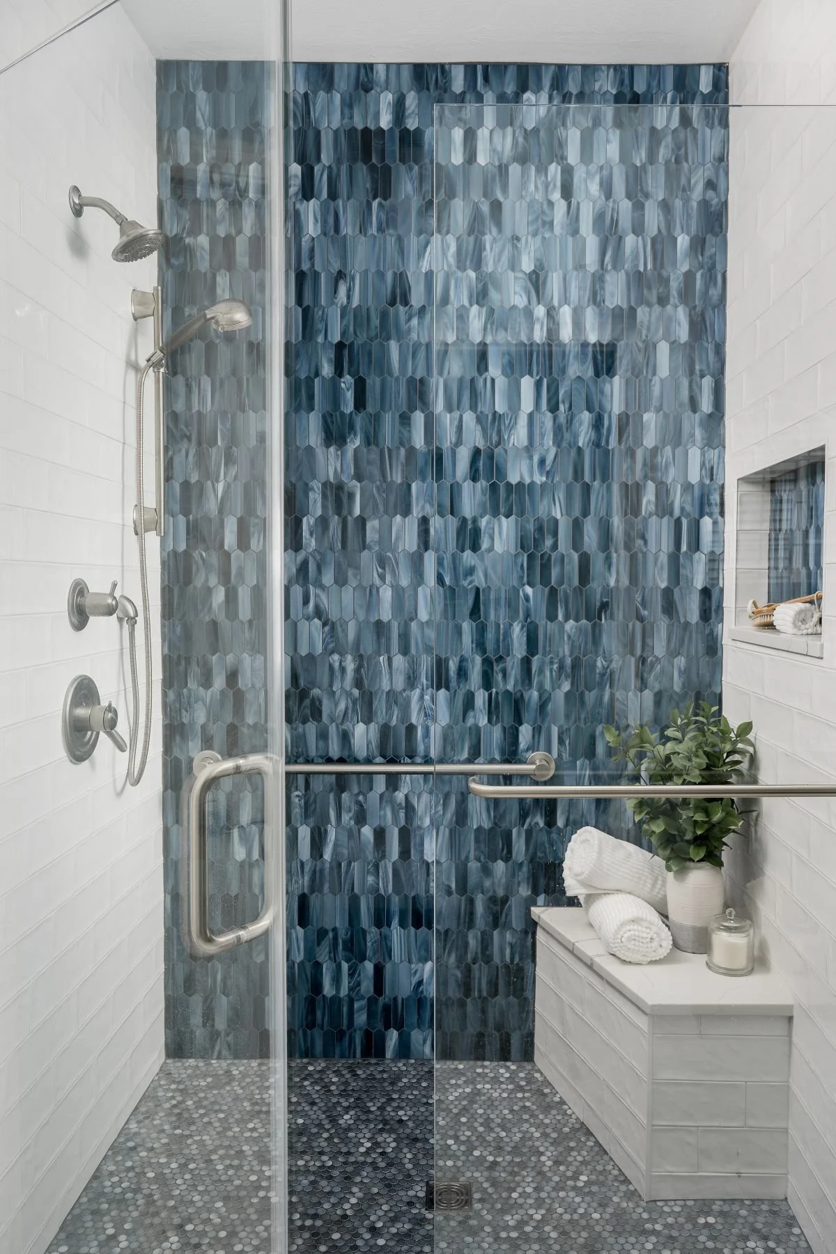 Luxury primary bathroom remodel with a freestanding tub and blue vanity cabinetry