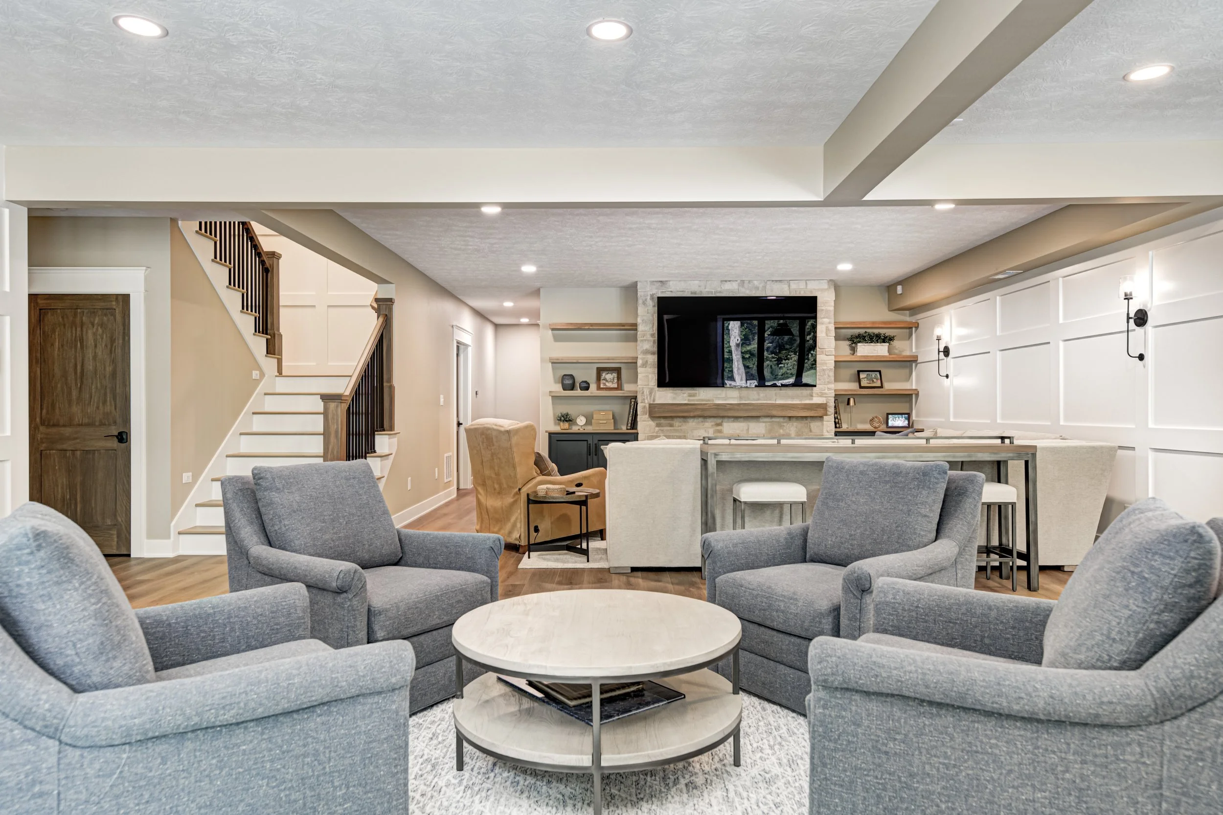 McCordsville custom basement remodel with a bar, seating areas and warm finishes